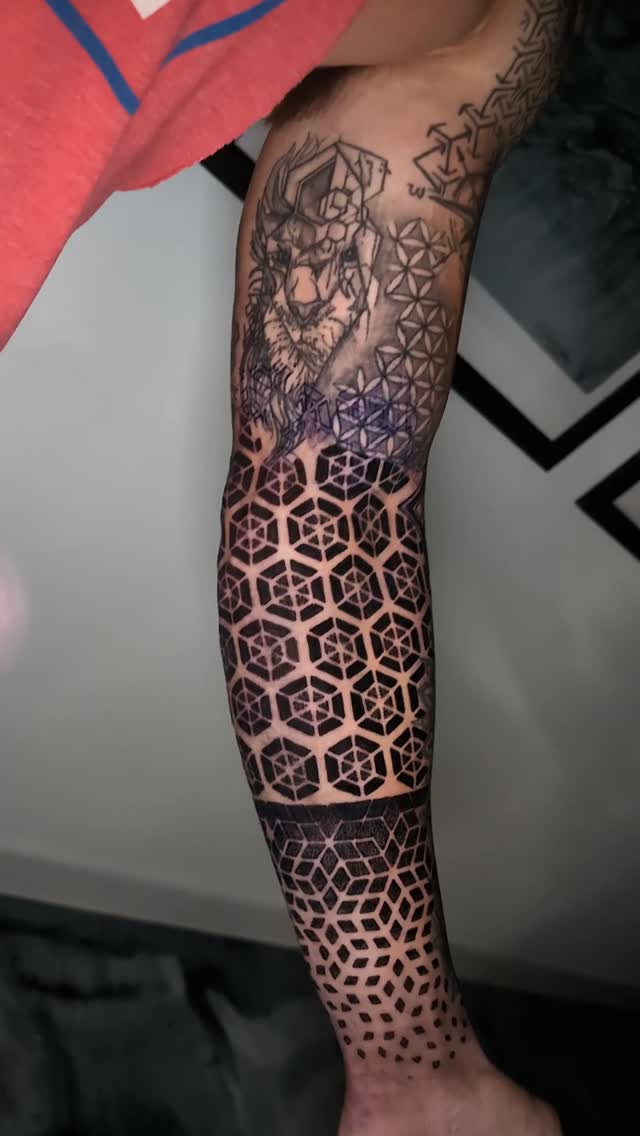 Finished geometric tattoo covering a forearm.